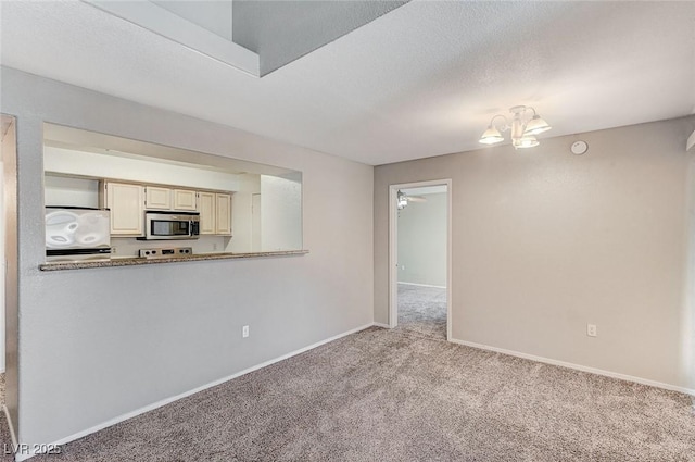 unfurnished living room with an inviting chandelier, light colored carpet, and a textured ceiling