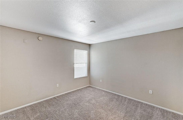 spare room featuring carpet floors and a textured ceiling