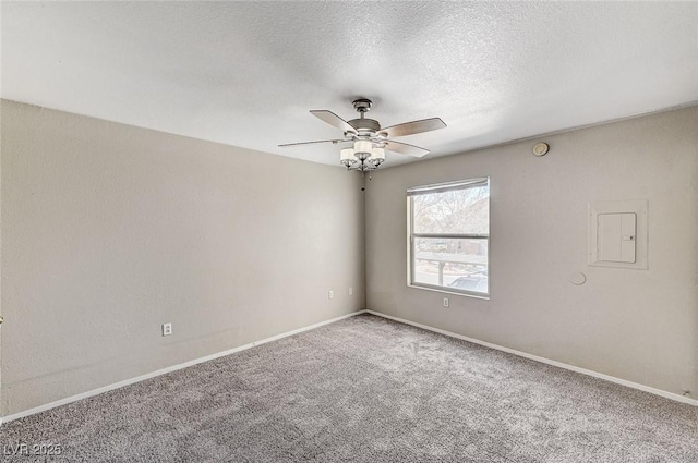 carpeted spare room featuring ceiling fan, electric panel, and a textured ceiling