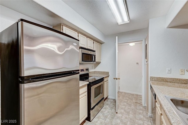 kitchen featuring sink, light stone countertops, a textured ceiling, and appliances with stainless steel finishes