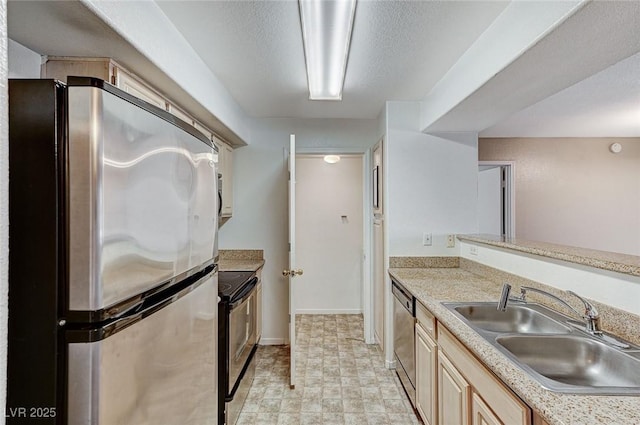 kitchen featuring stainless steel appliances, sink, a textured ceiling, and light brown cabinetry