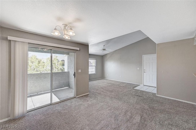 carpeted empty room with lofted ceiling, ceiling fan with notable chandelier, and a textured ceiling