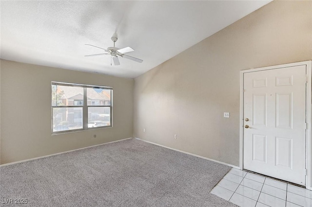 unfurnished room with ceiling fan, vaulted ceiling, light carpet, and a textured ceiling