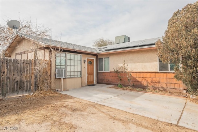 property entrance featuring cooling unit and solar panels