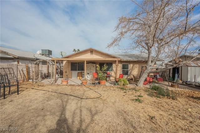 back of house with a storage shed, central AC unit, and a patio area