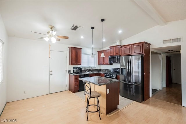 kitchen with a breakfast bar, pendant lighting, sink, a center island, and stainless steel appliances