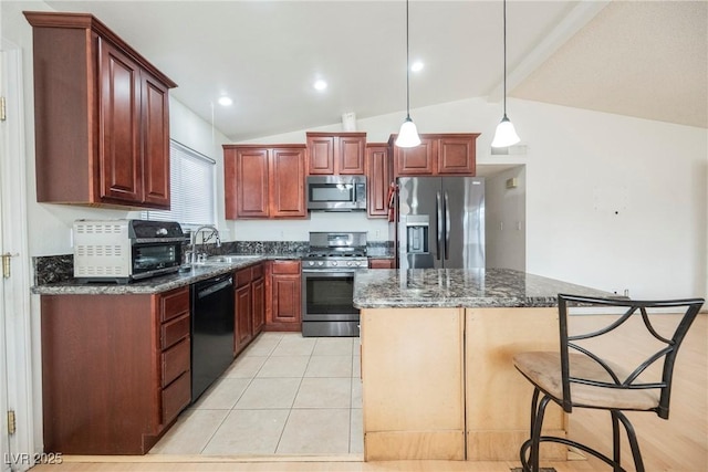 kitchen with a kitchen island, appliances with stainless steel finishes, decorative light fixtures, sink, and dark stone counters