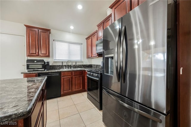 kitchen with dark stone counters, sink, light tile patterned floors, and black appliances