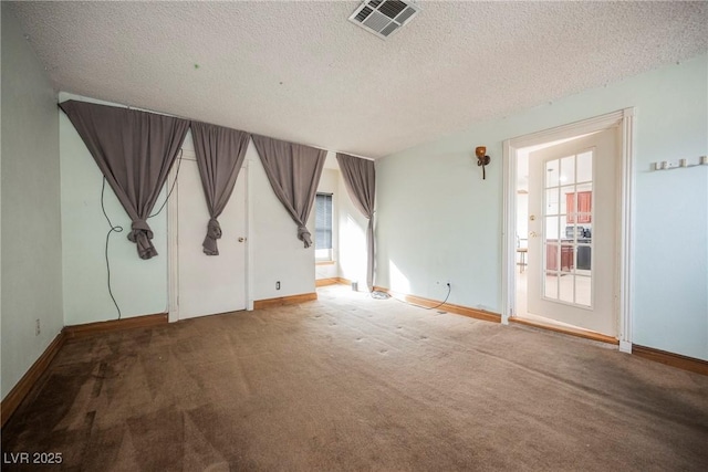 carpeted empty room with a textured ceiling