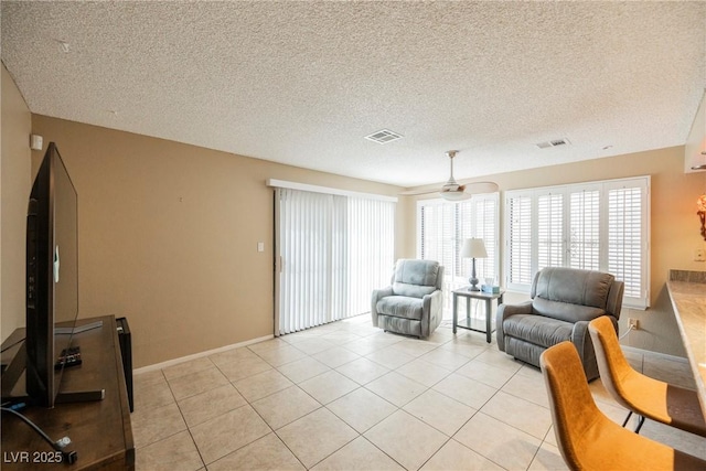 tiled living room featuring a textured ceiling