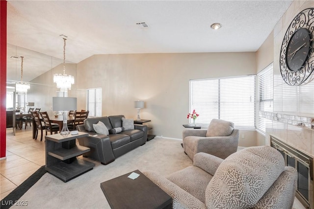 tiled living room featuring a chandelier and vaulted ceiling