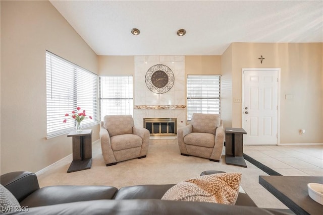 living room featuring lofted ceiling, tile patterned flooring, and a tile fireplace