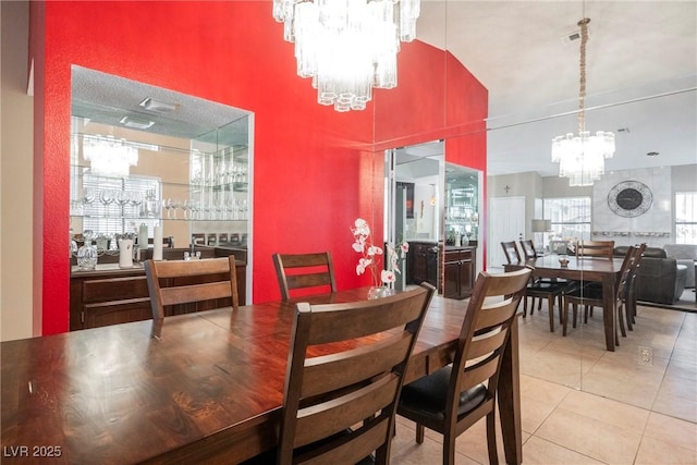 dining space featuring light tile patterned floors and a chandelier