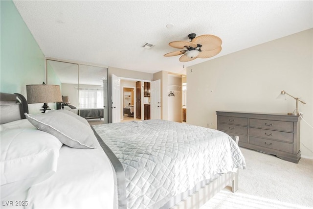 bedroom featuring light carpet, ceiling fan, and a textured ceiling