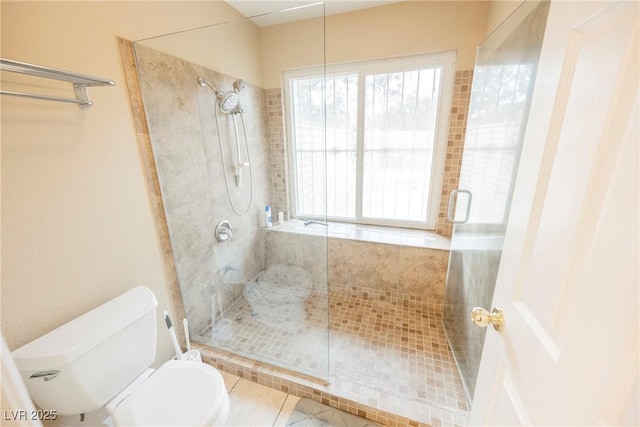 bathroom featuring toilet, tile patterned flooring, and a shower with door