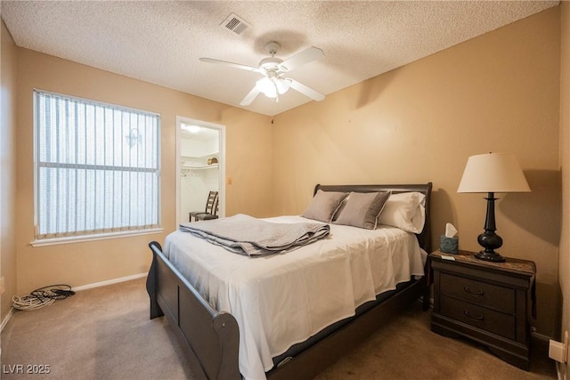 bedroom with ceiling fan, carpet flooring, and a textured ceiling