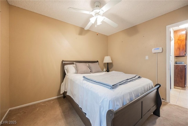 bedroom featuring ceiling fan, light colored carpet, and a textured ceiling