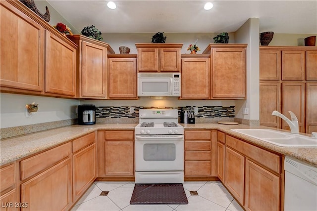 kitchen featuring light tile patterned floors, light countertops, white appliances, and a sink