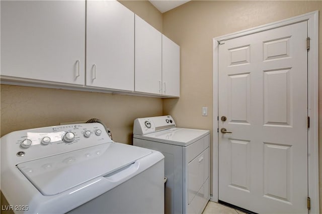 washroom with cabinet space and washing machine and clothes dryer