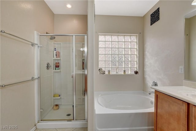 bathroom featuring a stall shower, a garden tub, and vanity