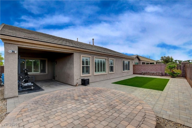 back of property with a patio, a fenced backyard, and stucco siding