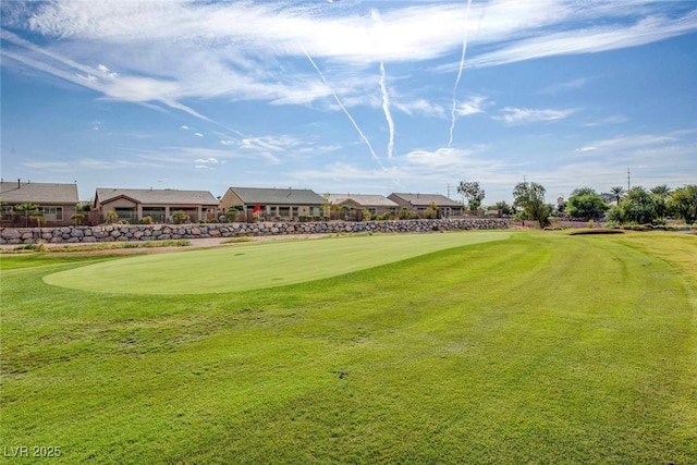 view of community with a yard and golf course view