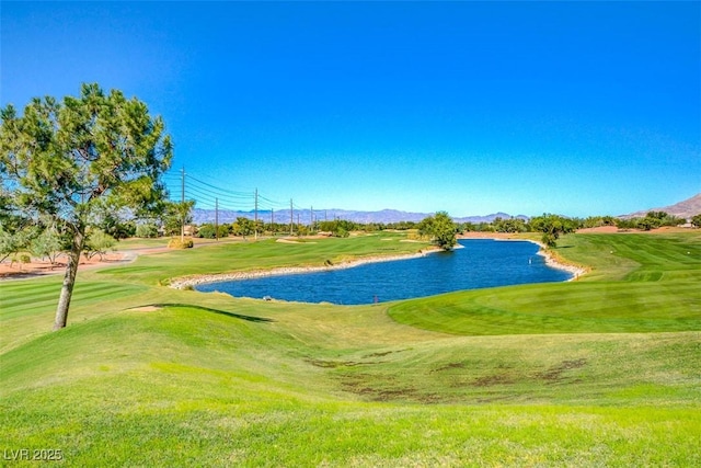 view of community featuring view of golf course, a lawn, and a water and mountain view