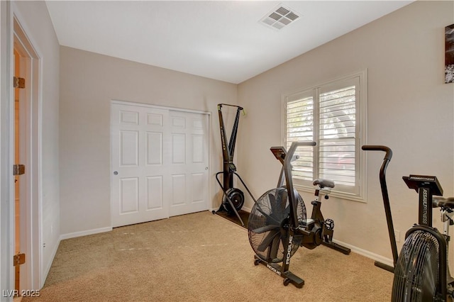 exercise room with baseboards, visible vents, and light colored carpet