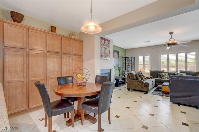 dining room with a fireplace and a ceiling fan