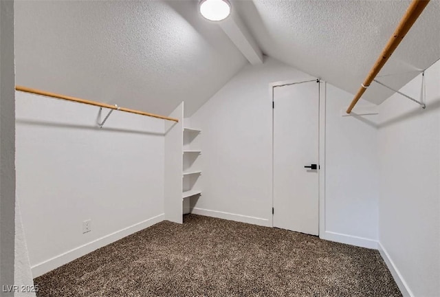 walk in closet featuring lofted ceiling with beams and dark carpet