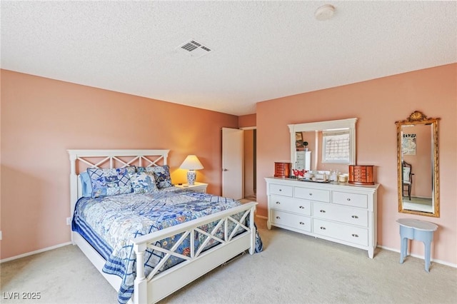 bedroom featuring light colored carpet and a textured ceiling