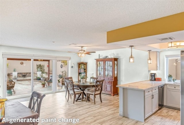 kitchen featuring light stone counters, stainless steel dishwasher, kitchen peninsula, pendant lighting, and ceiling fan