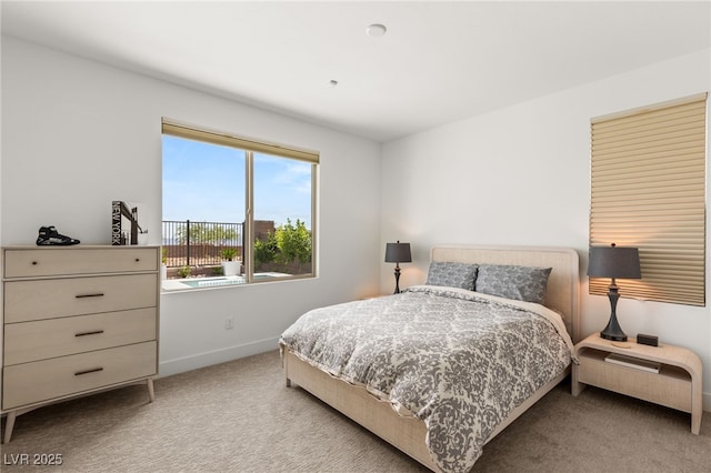 bedroom with baseboards and light colored carpet