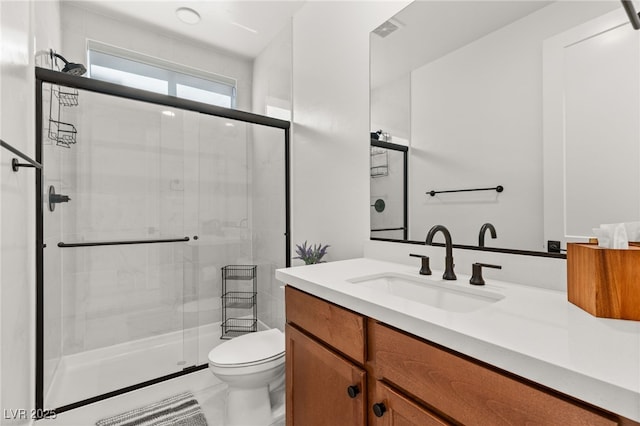 full bath featuring a stall shower, vanity, and toilet