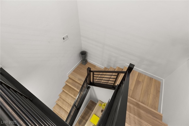 stairway with baseboards and wood finished floors