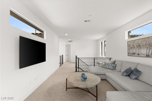 living area with light colored carpet, visible vents, and baseboards