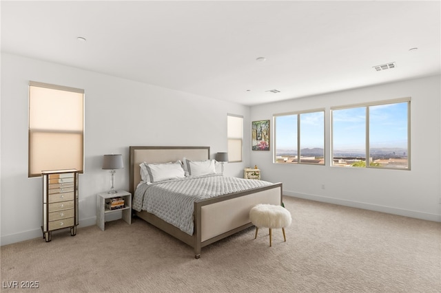 bedroom featuring baseboards, visible vents, and light colored carpet