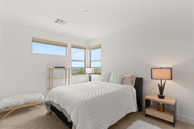 carpeted bedroom featuring visible vents and baseboards