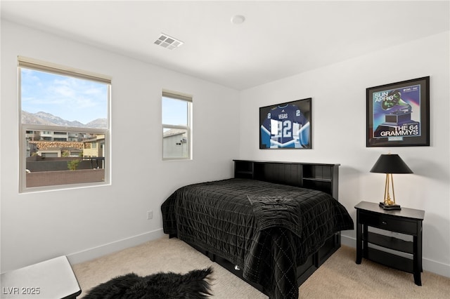 carpeted bedroom featuring baseboards, visible vents, and a mountain view