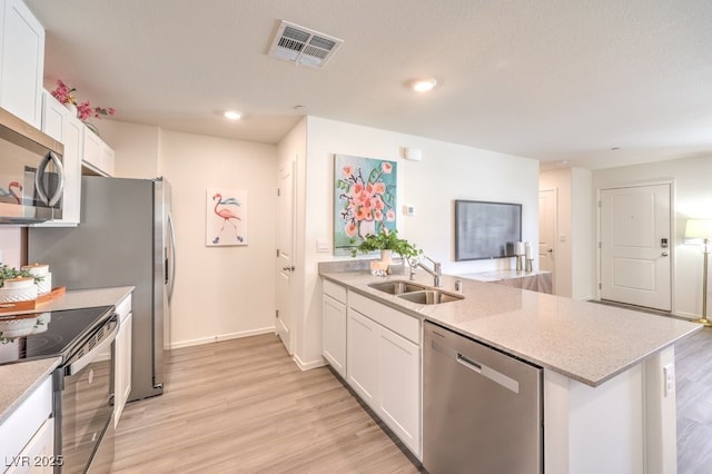 kitchen with appliances with stainless steel finishes, sink, light hardwood / wood-style flooring, and white cabinets