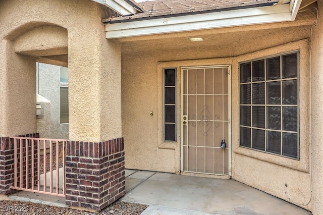 view of exterior entry with a patio