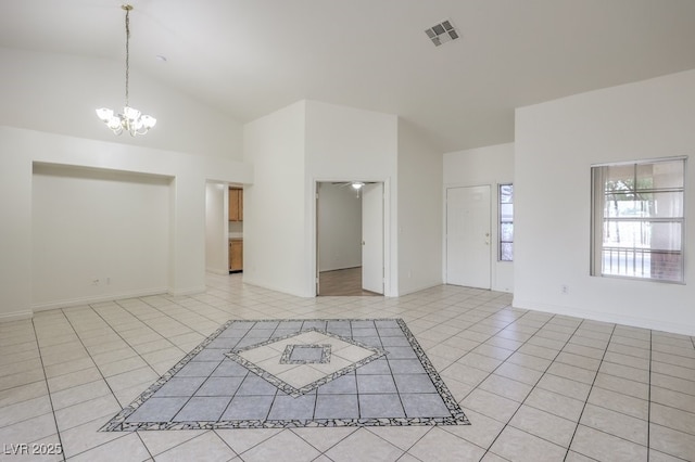 tiled empty room with high vaulted ceiling and a notable chandelier