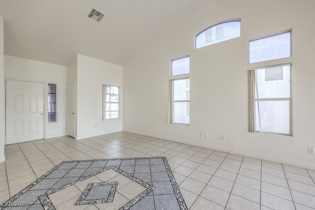 interior space featuring light tile patterned flooring and high vaulted ceiling