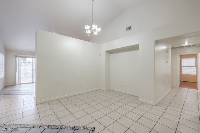 empty room featuring lofted ceiling, light tile patterned floors, and an inviting chandelier