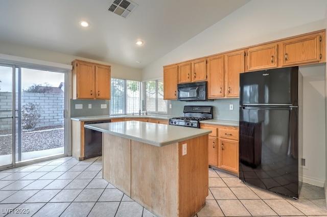 kitchen featuring light tile patterned floors, sink, a center island, black appliances, and vaulted ceiling