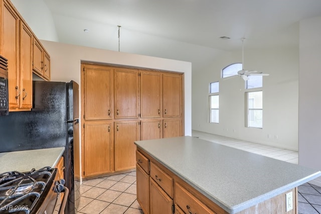 kitchen with vaulted ceiling, a kitchen island, and light tile patterned flooring