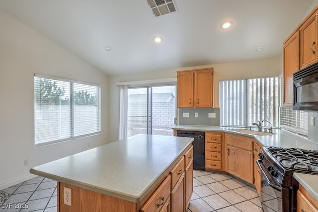 kitchen featuring sink, light tile patterned floors, a center island, black appliances, and vaulted ceiling