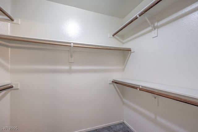 spacious closet with dark tile patterned floors