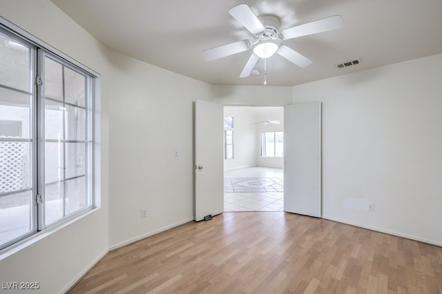 spare room with ceiling fan and light wood-type flooring