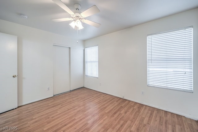 unfurnished bedroom featuring a closet, ceiling fan, and light wood-type flooring